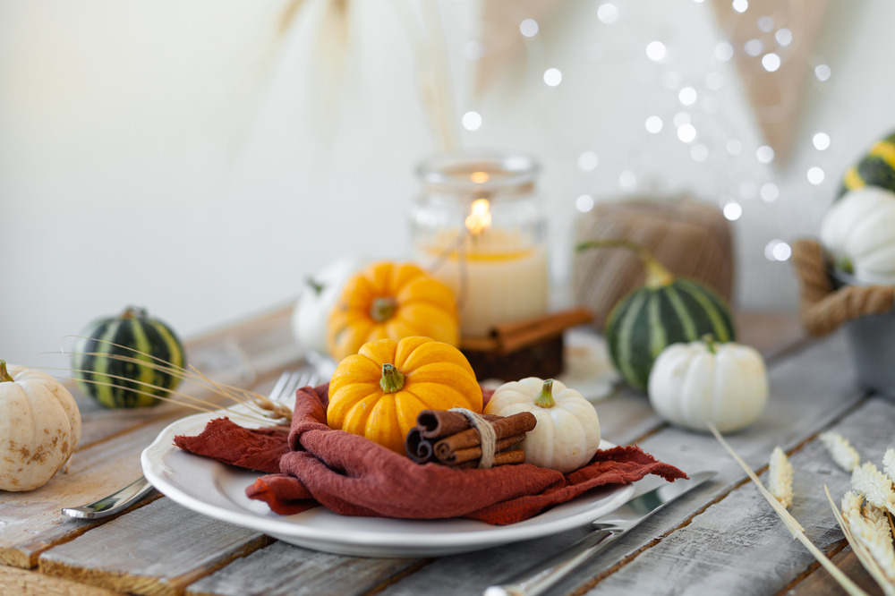 Autumn dining  table setting with pumpkins and candles.